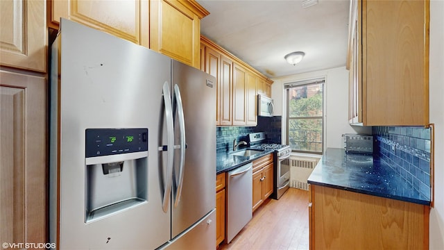 2190 Brigham St Unit 4B, Brooklyn, NY 11229 - kitchen featuring stainless steel appliances, backsplash, light wood-style flooring, radiator, and light brown cabinetry
