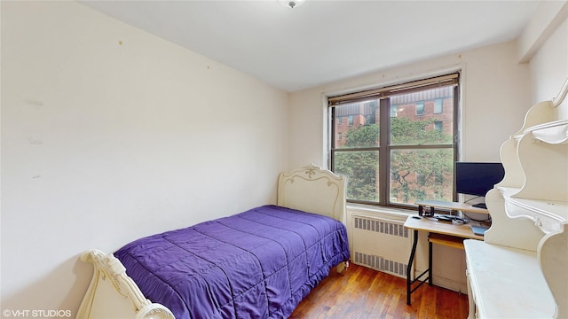 2190 Brigham St Unit 4B, Brooklyn, NY 11229 - bedroom featuring radiator heating unit, wood finished floors, and an office area