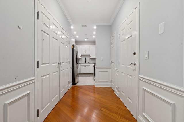 257 Central Ave Unit 1D, White Plains, NY 10606 - corridor featuring ornamental molding, a wainscoted wall, a decorative wall, light wood-style floors, and recessed lighting