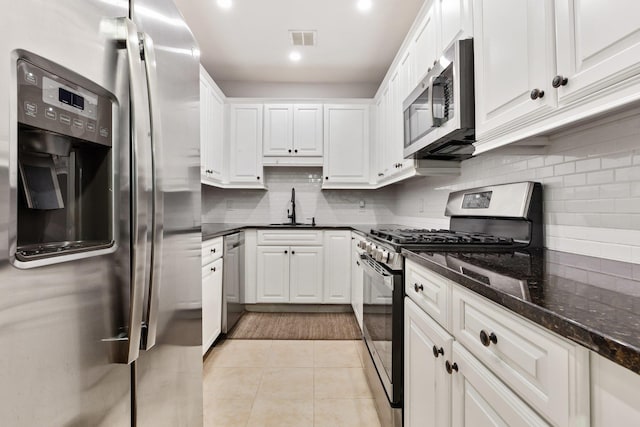 257 Central Ave Unit 1D, White Plains, NY 10606 - kitchen with stainless steel appliances, white cabinets, decorative backsplash, light tile patterned flooring, and recessed lighting