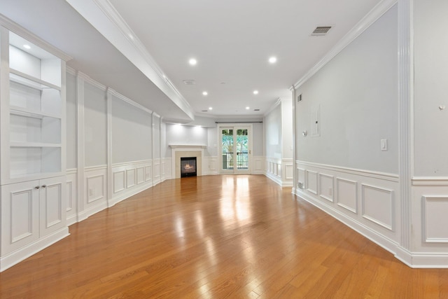 257 Central Ave Unit 1D, White Plains, NY 10606 - unfurnished living room featuring a decorative wall, light wood-type flooring, a glass covered fireplace, ornamental molding, and recessed lighting