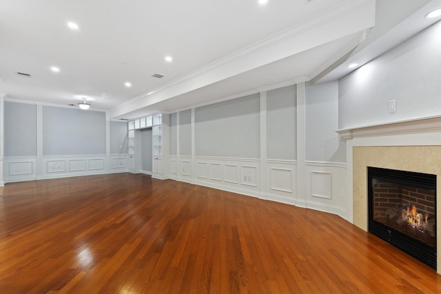 257 Central Ave Unit 1D, White Plains, NY 10606 - unfurnished living room featuring a decorative wall, a high end fireplace, crown molding, wood finished floors, and wainscoting