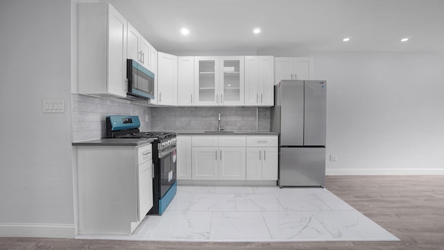 3604 Willett Ave, Bronx, NY 10467 - kitchen featuring stainless steel appliances, white cabinets, glass insert cabinets, tasteful backsplash, and recessed lighting