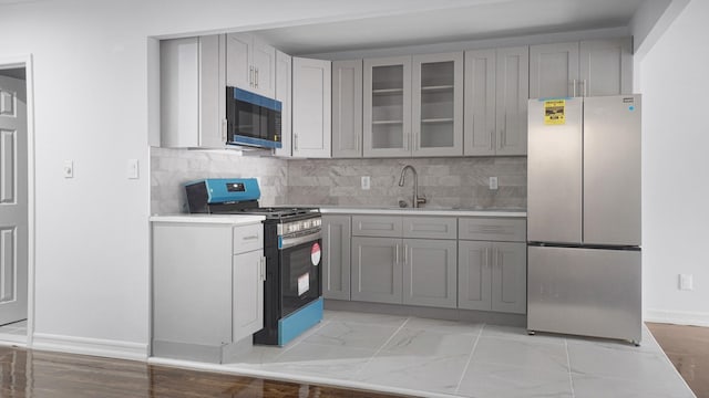 3604 Willett Ave, Bronx, NY 10467 - kitchen with stainless steel appliances, gray cabinets, light countertops, glass insert cabinets, and backsplash