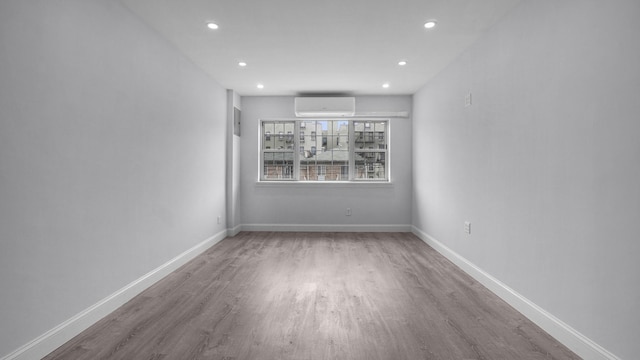 3604 Willett Ave, Bronx, NY 10467 - empty room featuring a wall unit AC, recessed lighting, and wood finished floors
