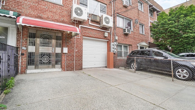 3604 Willett Ave, Bronx, NY 10467 - entrance to property with a garage, brick siding, concrete driveway, and cooling unit
