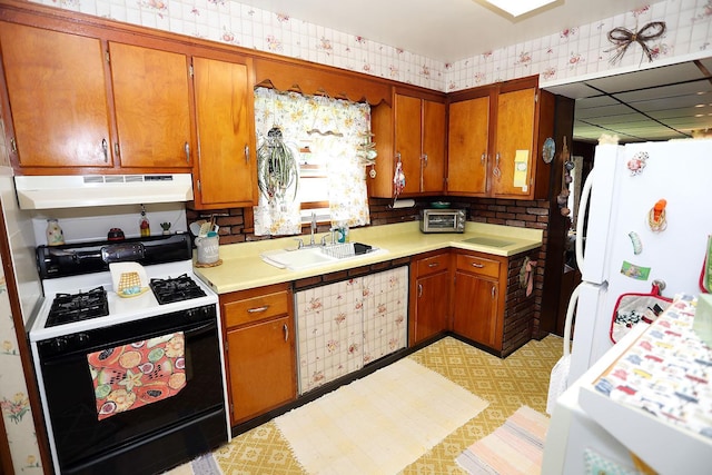 3027 State Route 17b, Cochecton, NY 12726 - kitchen with gas stove, under cabinet range hood, light countertops, brown cabinets, and wallpapered walls