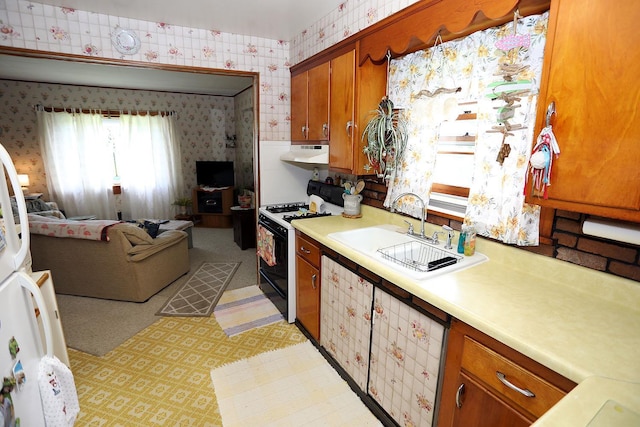 3027 State Route 17b, Cochecton, NY 12726 - kitchen with gas range, wallpapered walls, under cabinet range hood, light countertops, and brown cabinets