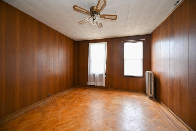 43-44 168th St, Flushing, NY 11358 - spare room with radiator, wooden walls, ceiling fan, and light flooring