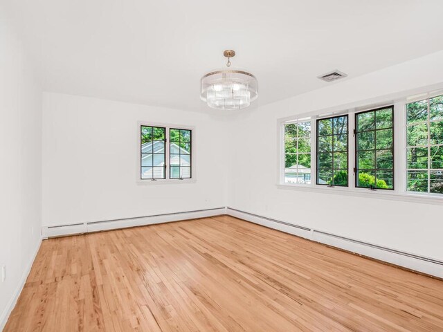 17 Shenorock Dr, Yorktown Heights, NY 10598 - spare room with healthy amount of natural light, baseboard heating, wood finished floors, and a chandelier