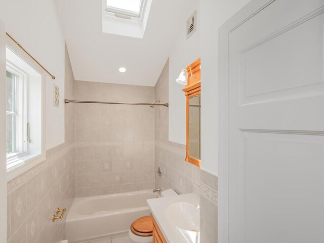 17 Shenorock Dr, Yorktown Heights, NY 10598 - full bathroom featuring tile walls, vanity, shower / bathtub combination, a skylight, and wainscoting