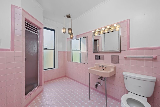 527 57th St, Brooklyn, NY 11220 - bathroom featuring tile walls, crown molding, a shower stall, wainscoting, and tile patterned floors