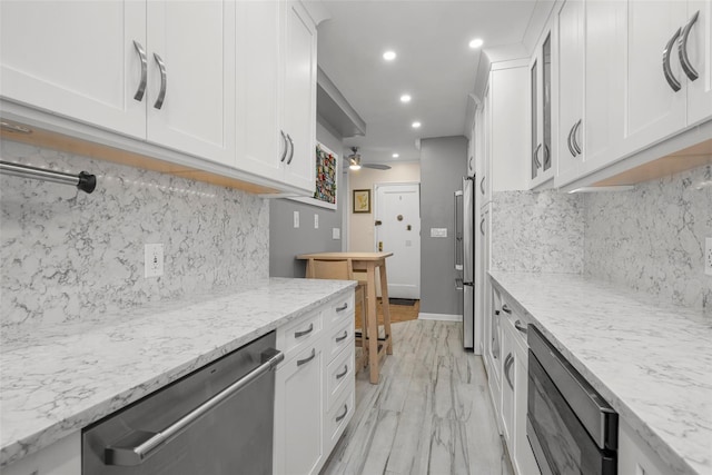 620 W 239th St Unit 2C, Bronx, NY 10463 - kitchen with stainless steel appliances, white cabinetry, recessed lighting, a ceiling fan, and decorative backsplash