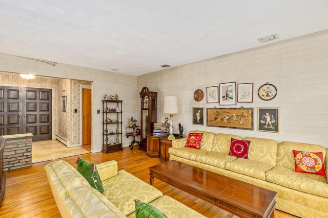 15 Carol Ct, Dix Hills, NY 11746 - living room with a baseboard heating unit, wallpapered walls, and wood finished floors