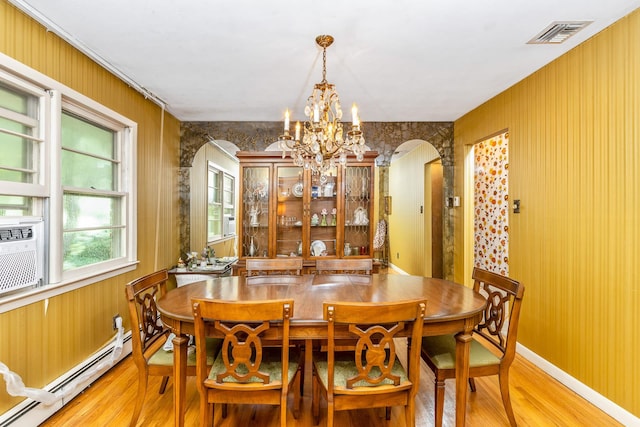15 Carol Ct, Dix Hills, NY 11746 - dining area with arched walkways, light wood-type flooring, a baseboard radiator, and a chandelier