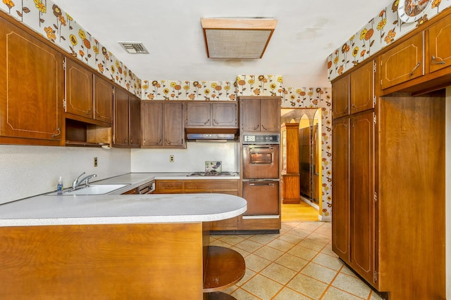 15 Carol Ct, Dix Hills, NY 11746 - kitchen with a peninsula, wallpapered walls, light countertops, stainless steel gas stovetop, and light tile patterned flooring