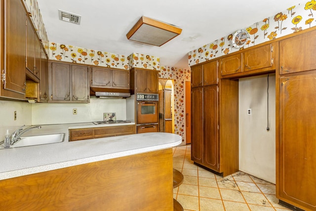15 Carol Ct, Dix Hills, NY 11746 - kitchen featuring wall oven, wallpapered walls, under cabinet range hood, cooktop, and a peninsula