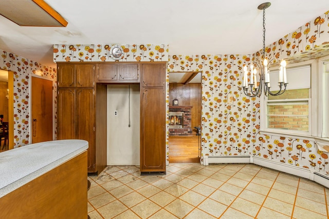 15 Carol Ct, Dix Hills, NY 11746 - kitchen featuring wallpapered walls, a chandelier, a fireplace, light tile patterned flooring, and brown cabinetry