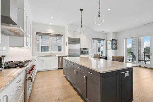 720 Davenport Ave Unit 3, New Rochelle, NY 10805 - kitchen featuring high end appliances, wall chimney range hood, a center island, white cabinetry, and light wood finished floors