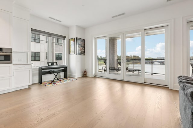 720 Davenport Ave Unit 3, New Rochelle, NY 10805 - kitchen featuring light wood-style flooring, white cabinets, a water view, light countertops, and stainless steel oven