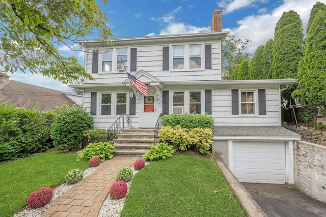 23 Jackson Ave, White Plains, NY 10606 - view of front facade featuring a chimney, an attached garage, a front lawn, and driveway