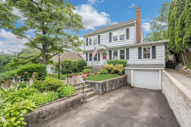 23 Jackson Ave, White Plains, NY 10606 - view of front of house featuring asphalt driveway, a chimney, and a garage