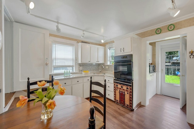 23 Jackson Ave, White Plains, NY 10606 - kitchen featuring rail lighting, white cabinets, light wood-type flooring, and crown molding