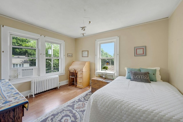 23 Jackson Ave, White Plains, NY 10606 - bedroom with radiator heating unit, wood finished floors, and cooling unit