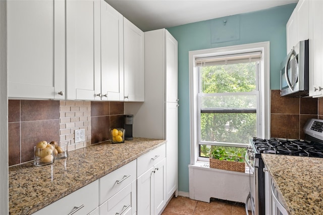 30 Clinton Pl Unit 2F, New Rochelle, NY 10801 - kitchen with stainless steel appliances, light stone countertops, and white cabinetry