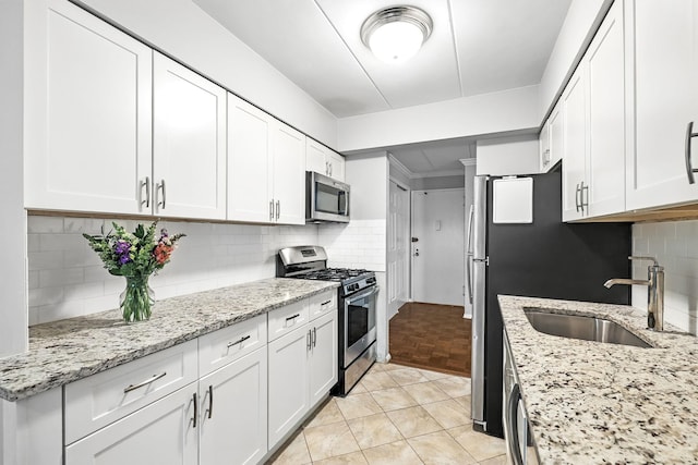 370 Central Park Ave Unit 3D, Scarsdale, NY 10583 - kitchen with appliances with stainless steel finishes, white cabinets, decorative backsplash, and light stone counters