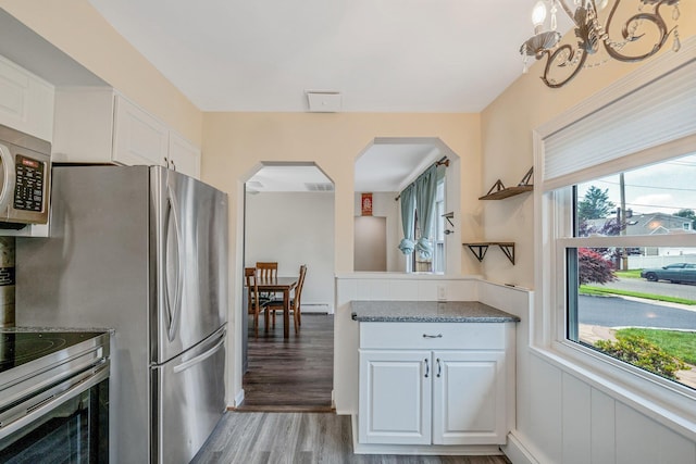 19 Buttercup Ln, Levittown, NY 11756 - kitchen with stainless steel appliances, arched walkways, light wood-style floors, and plenty of natural light