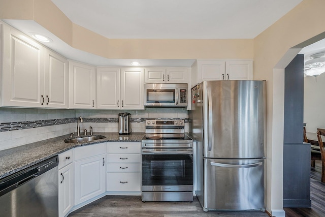 19 Buttercup Ln, Levittown, NY 11756 - kitchen featuring appliances with stainless steel finishes, dark wood-type flooring, white cabinetry, and dark stone countertops