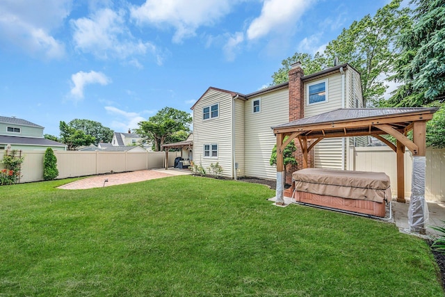 19 Buttercup Ln, Levittown, NY 11756 - back of house featuring a hot tub, a gazebo, a patio, a fenced backyard, and a chimney