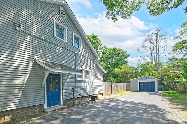 15 5th Ave, Kings Park, NY 11754 - view of side of home featuring a detached garage, asphalt driveway, and an outdoor structure