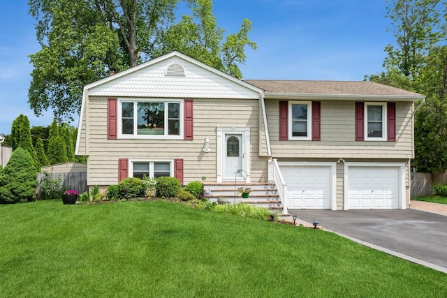 9 Phyllis Ct, Kings Park, NY 11754 - raised ranch featuring asphalt driveway, a garage, a front lawn, and roof with shingles