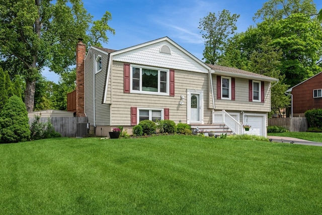 9 Phyllis Ct, Kings Park, NY 11754 - split foyer home with a chimney, a garage, and driveway