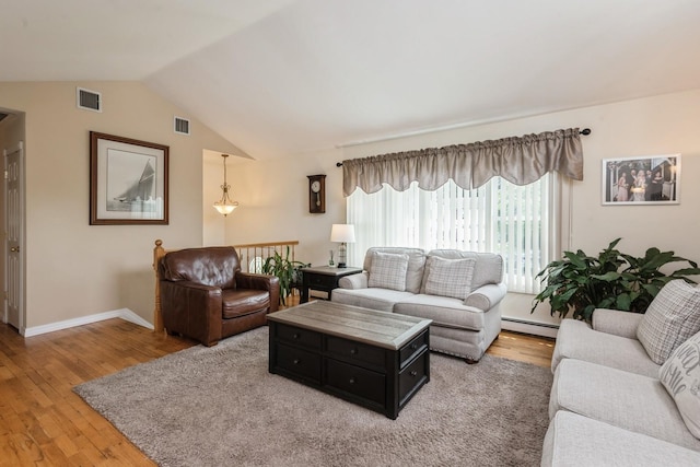 9 Phyllis Ct, Kings Park, NY 11754 - living area with a baseboard heating unit, light wood-type flooring, and lofted ceiling