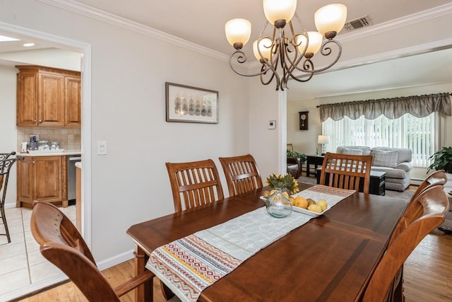 9 Phyllis Ct, Kings Park, NY 11754 - dining area with a chandelier, ornamental molding, and light wood-style floors