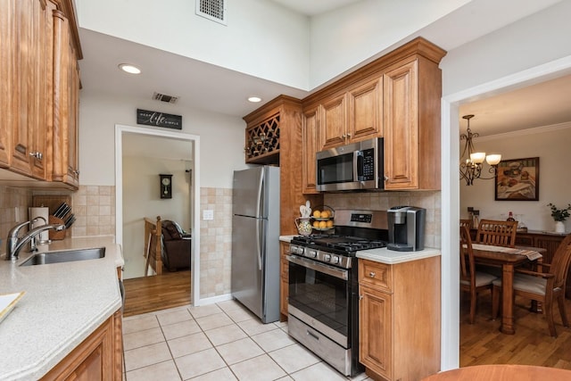 9 Phyllis Ct, Kings Park, NY 11754 - kitchen with stainless steel appliances, light countertops, brown cabinetry, a chandelier, and recessed lighting