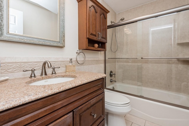 9 Phyllis Ct, Kings Park, NY 11754 - bathroom featuring vanity, tile walls, shower / bath combination with glass door, tile patterned flooring, and a wainscoted wall