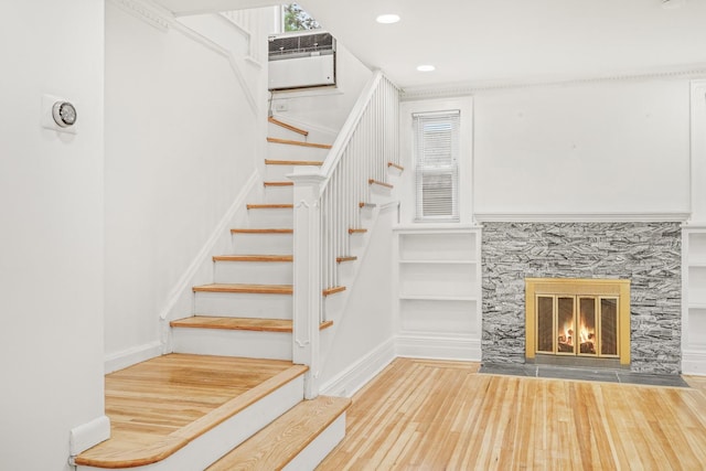 37 Keystone Pl, Hewlett, NY 11557 - stairway featuring wood finished floors, recessed lighting, a wall mounted air conditioner, a glass covered fireplace, and built in features