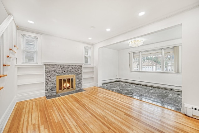 37 Keystone Pl, Hewlett, NY 11557 - unfurnished living room featuring hardwood / wood-style flooring, a baseboard radiator, built in shelves, a fireplace, and baseboard heating