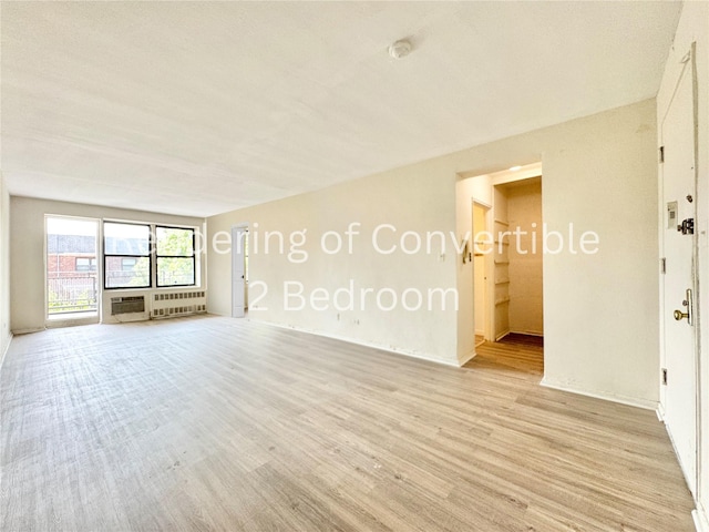 87-10 51st Ave Unit 3E, Elmhurst, NY 11373 - empty room featuring light wood finished floors, a smoke detector, and radiator
