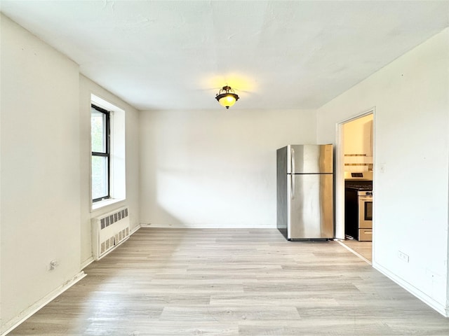87-10 51st Ave Unit 3E, Elmhurst, NY 11373 - empty room with radiator and light wood finished floors