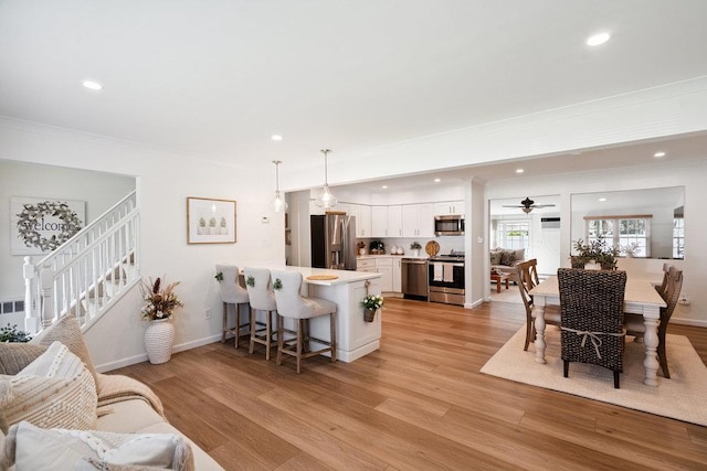 531 Myrtle Ave, West Islip, NY 11795 - living area with ornamental molding, recessed lighting, a ceiling fan, light wood-style floors, and stairway