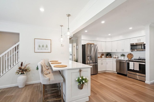 531 Myrtle Ave, West Islip, NY 11795 - kitchen with appliances with stainless steel finishes, a peninsula, light countertops, light wood finished floors, and crown molding