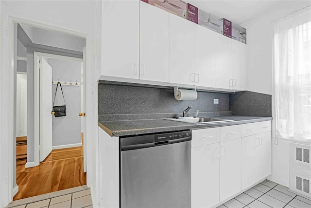 22424 Union Tpke Unit 3C, Oakland Gardens, NY 11364 - kitchen featuring dishwasher, radiator heating unit, light tile patterned flooring, white cabinetry, and backsplash