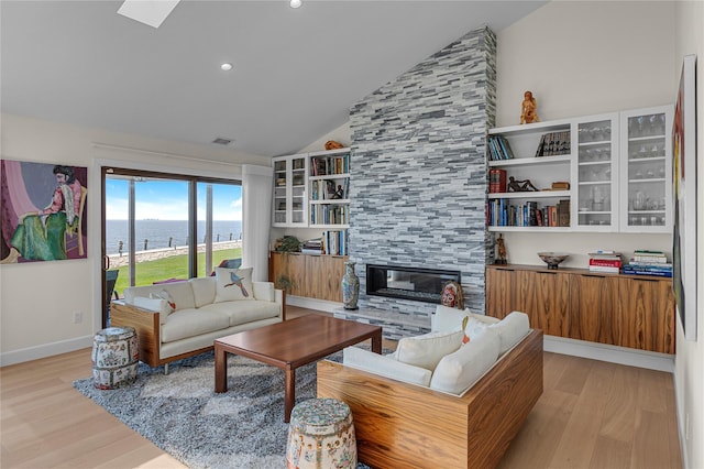 9 Captains Walk E, Bay Shore, NY 11706 - living area with light wood-style floors, a water view, a tile fireplace, recessed lighting, and high vaulted ceiling