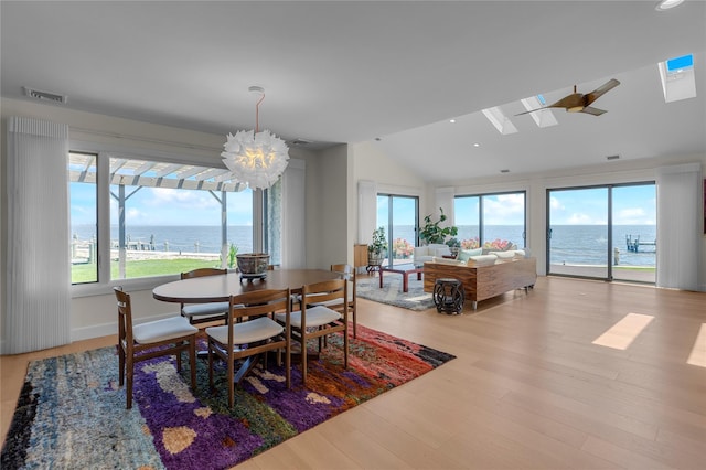 9 Captains Walk E, Bay Shore, NY 11706 - dining space with vaulted ceiling, healthy amount of natural light, a water view, wood finished floors, and recessed lighting