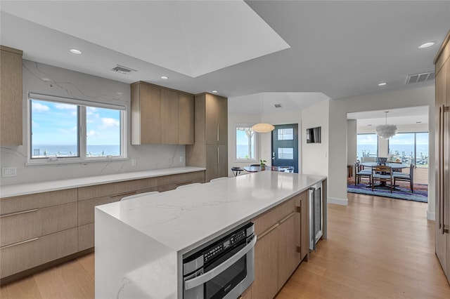 9 Captains Walk E, Bay Shore, NY 11706 - kitchen featuring light wood-style floors, modern cabinets, recessed lighting, a kitchen island, and backsplash